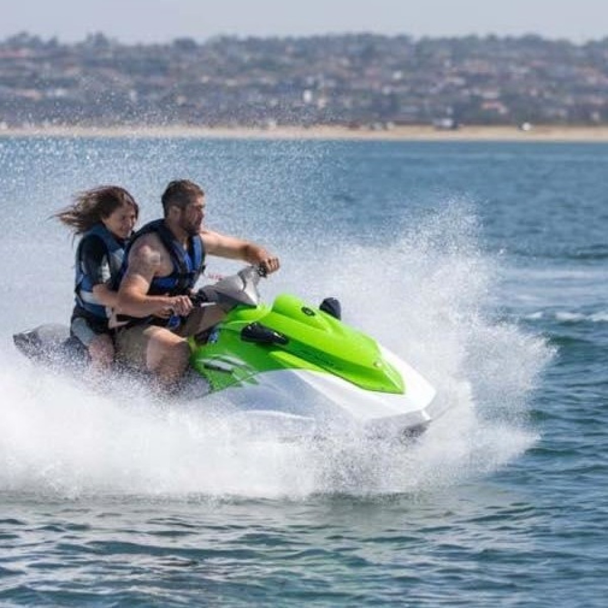 two people riding green jet ski