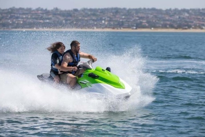 two people riding green jet ski
