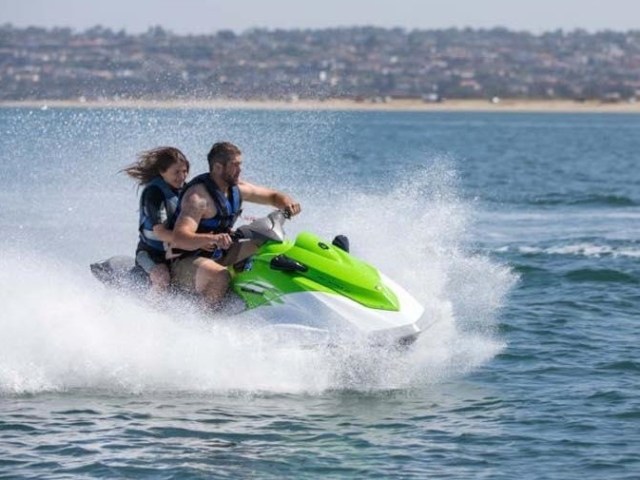 two people riding green jet ski